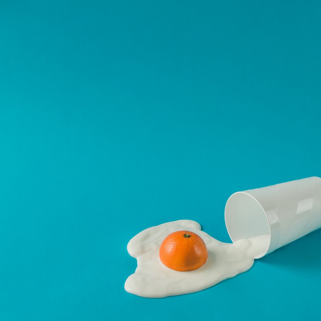 Creative breakfast layout. Orange and yogurt fried egg. Flat lay. Food concept